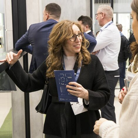 Sales person guiding clients at the BAU 2025 booth.