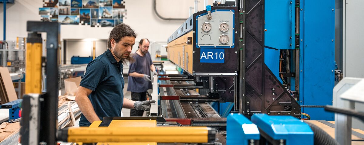 Two Reynaers Aluminium employees working at the insulation assembly line.