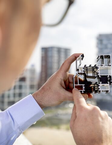 Architect examining aluminum window profile cross-section
